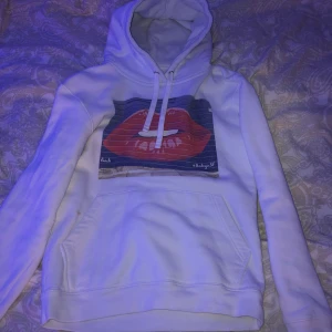 The cool elephant hoodie  - En vit hoodie från the cool elephant med tryck av läppar 👄.  Den har en liten fläck vid fickan dock(kolla sida 2). Annars jättefin och i ganska bra skick, 7/10. Aldrig använt pga för stor men tvättat så den är lite nopprig. Strl xs/s (tycker jag)stor i strl. 