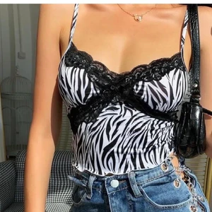 Zebra crop top - Crop top i zebra mönster å svart spets. Den e använd varsamt å e in princip i nyskick. Lägg ditt bud i kommentarerna, om fler e intresserade blir de budgivning 🤍🖤 (första bilden lånad) kom priv för frågor elr fler bilder)  GRATIS FRAKT