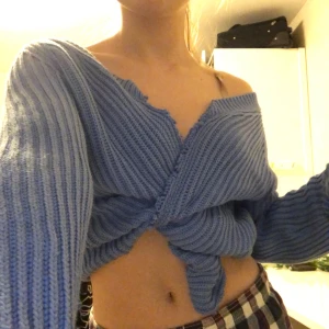 Klippt stickad tröja - Har klippt denna blåa stickade tröjan som man kan knyta på massa söta sätt