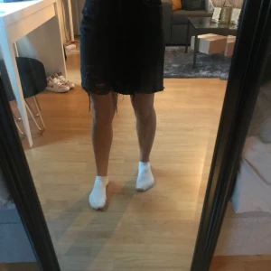 Jeanskjol  - En mörk grå jeanskjol med hål som är en super fin längd och går ihop till så mycket toppar! 