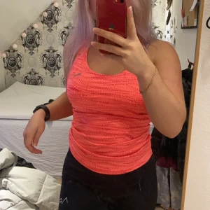 Träningslinne Puma - Säljer detta färgglada träningslinne från Puma som är för litet för mig i bysten, den har inbyggd sport-bh vilket är jätteskönt och bra. Det är lagom långt och har brottarrygg. Köparen står för frakten.