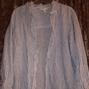 Skjorta - En randig skjorta i blåa och vita ränder. Tyg material. Använd bara några fåtal gånger.