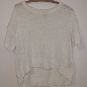  - Enkel vit stickad tröja med lite längre armar än en vanlig kortärmad Längre baktill och mer croppad fram Knappt använd Frakt betalas av köparen 