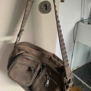  - En noella väska i den lilla modellen. den ändrat färg då den glömdes ute i solen i Spanien i sommar och den då blev solblekt vilket gör att den skiftar åt det orange/beiga hållet vilket är såååå synd då den var grå från början, pris diskuterbart