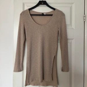 H&M lång tröja - Snygg beige tröja från H&M! Aldrig använd då den inte är min personliga stil. Frakt ingår i priset