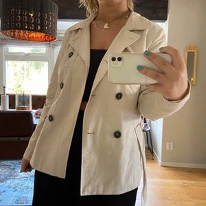 Beige kappa  - En beige tunn kappa med svarta runda knappar på från only. Använt 2/3 gånger derför i perfekt skick! Ny pris 500kr 