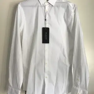 En festlig vit skjorta i storlek S. Slim fit med stretchigt material. Köparen står för frakten! (Herr)