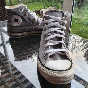 Gråa Converse  - Riktigt snygga, gråa Converse. Ena skon är skavd lite vid hälen och conversemärkena är slitna efter att jag tvättade skorna. Annars i bra skick, sparsamt använda. Pma för fler bilder. Frakten ingår!