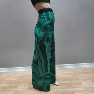 Mönstrade byxor - Vida byxor med hög midja och grönt, härligt mönster. Sköna och "flowiga". Riktigt snygga på, särskilt när man rör sig. Ganska långa ben, men går självklart att sy upp om man vill. Strl XS. Frakt tillkommer.