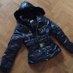  - Michael Kors dunjacka med silverdetaljer, bälte i midjan som är avtagbart. Svart päls på luvan som är otroligt len! Varm och skön. Nypris ca 2300kr.
