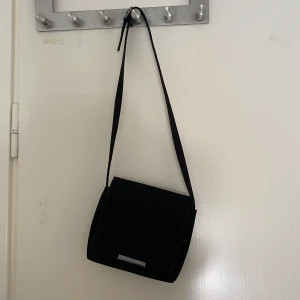 Väska - Snygg väska i nylontyg typ. Har kortat bandet så att den sitter i en snygg höjd över axeln (korsat). Köps innan 21/8 annars skänks den💕💕