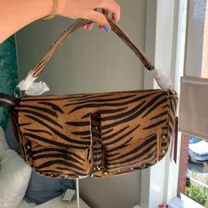 Unlimit shoulder bag emily - Helt ny och oanvänd väska! Med tiger mönster. Köpte den för 1899kr. Köparen står för frakt men kan även mötas upp i centrala Sthlm. 