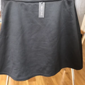 Kjol i polyester  - Svart kjol i polyester med prislapp kvar. Stretchig