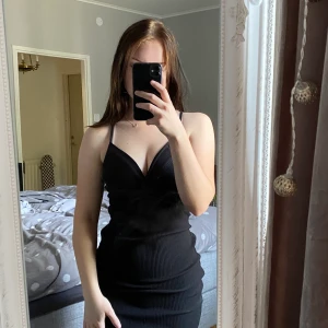 Ribbad stretchig klänning - Fin klänning som passar många olika tillfällen. Jag har S men den är stretchig så kan även passa större. Använd en gång! 