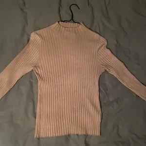 beige ribbad polo/ turtleneck - En ljusare beige färgad långärmad polo. Mjukt tyg och krage som inte viks men är tillräckligt kort. Sitter bra på mig som är S/M. Originalpris 400 kr.