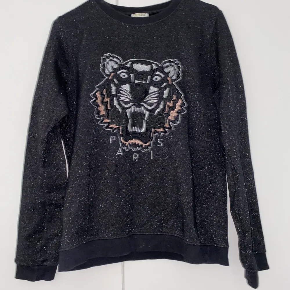 Svart och lite glittrig Kenzo sweatshirt. Bilderna är tagna med blixt för att glittret ska synas. Den är från barnavdelningen men är som storlek S. Funkar på xs och M beroende på hur man bil att den ska sitta. Buda i chatten.. Tröjor & Koftor.