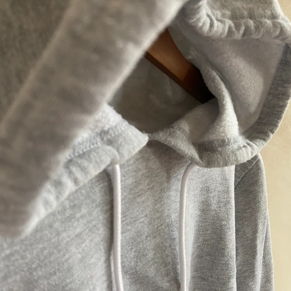 Midje-lång hoodie från Bikbok, extra mysigt tyg inuti. Med huva & med ”rå” kant (den ser ut att vara som avklippt i nederkanten). Säljer då den aldrig används. I storlek S och nytt skick. . Hoodies.