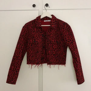 Röd leopardmönstrad jeans jacka - Kortare jeans jacka från NA-KD i bra skick. Storleken är 36, men den är liten i storleken så mer som en 34 ungefär. 