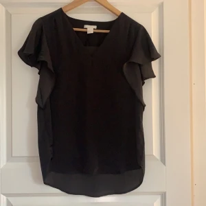 Grå V-ringad blus H&M - Jättefin grå v-ringad blus med volangarmar från H&M. Använd bara ett fåtal gånger. Storlek 34. Även denna blusen har ett jättefint fall. Säljer för 60kr. 