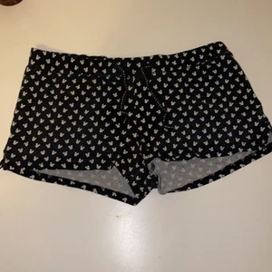 Mussepigg pyjamas-shorts  - Storlek XS men passar även XXS och mindre. Svarta med vita mussepigg huvuden, jättesöta men säljs då de är för små. Frakt tillkommer. Ganska använda så lite urtvättade