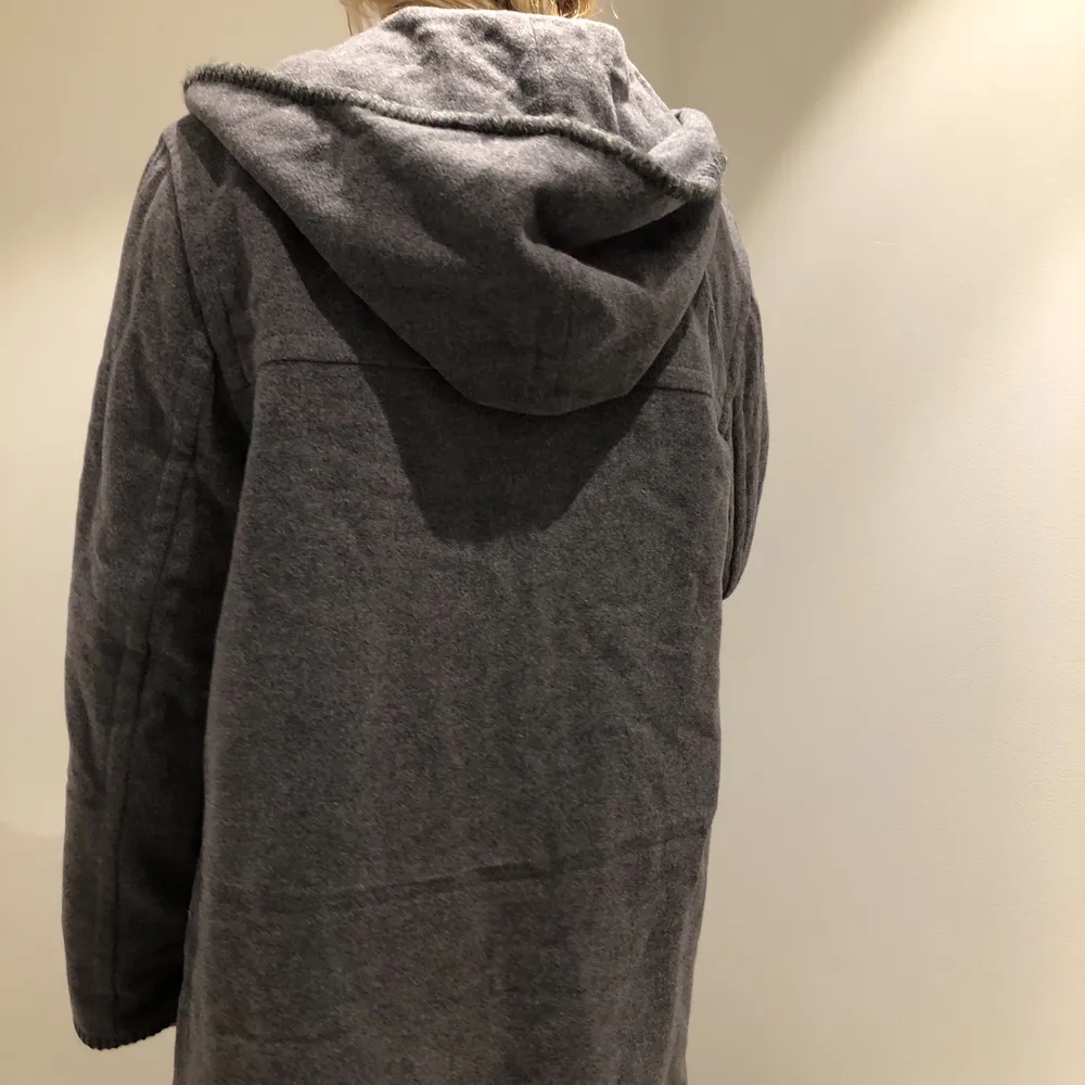 Grå kappa med huva i tjockt material och superfin kvalité. Den har svarta spännen framtill och är från märket PTA. Nyskick! Skriv gärna för fler bilder! Kan mötas upp eller skickas men köparen står då för frakten <3 (Säljer just nu massa fler kappor och jackor så kolla gärna in min profil!). Takit.