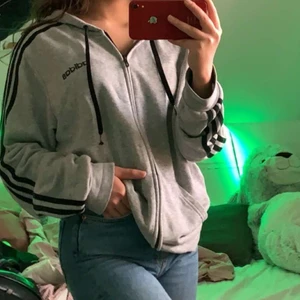Adidas original grå zip hoodie - Säljer denna sköna adidas zip hoodien eftersom den inte kommer till använding längre då jag har ändrat min stil lite. Den är i herrstorlek M men passar bra som oversized på mig som ändå är ganska liten i storlek. Den är i mycket bra skick. Köpare står för frakt. 
