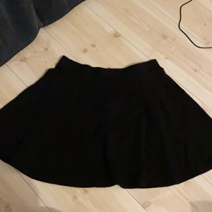 Kjol från H&M - En svart kort kjol från H&M i storlek M. Använt mycket fint skick. Dragkedja på baksidan.