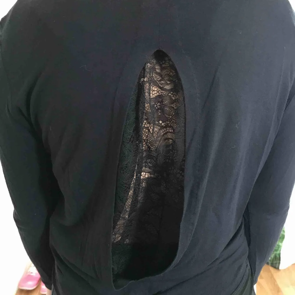 By Malene Birger  En svart långärmad tröja med ett hål i ryggen som täcks över spetstyg.  Frakt tillkommer. . Tröjor & Koftor.