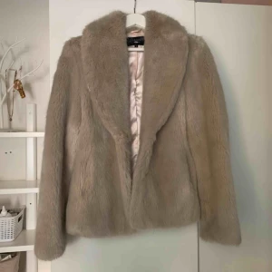  - I princip oanvänd holliesjacka inköpt för ett par år sedan. Ljusbeige och varm. Fin krage, fickor och två knäppen. Köparen står för frakt. Pris kan diskuteras 😊  
