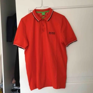 Hugo boss pikétröja  - Röd-orange pikétröja från Hugo Boss (man). Storlek S