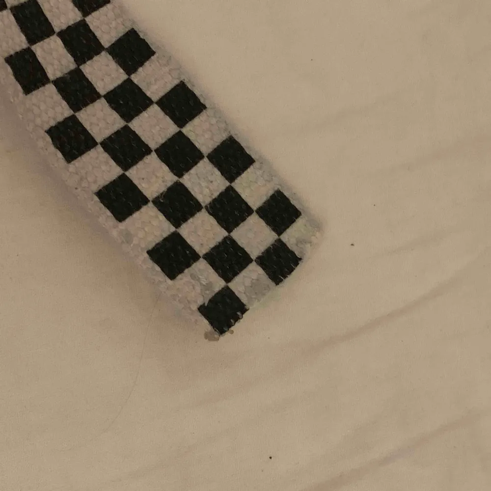 Checkered bälte som är ca 1 meter långt. Den var längre innan men har klippt av en del av den, dock märks det knappt att det är avklippt. Bältet har blivit lite grått just där jag spänt åt det . Accessoarer.