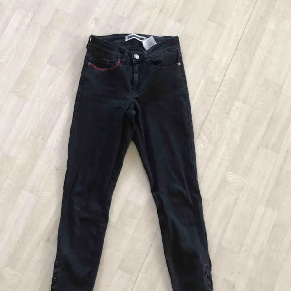 Svarta jeans med snörning vid ankeln. De röda går lätt att sprätta bort. Jag kan även göra de om de önskas. De är bara fråga om du undrar nått men frakt tillkommer. Jeans & Byxor.