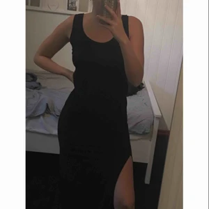  - En jätte fin svar långklänning. Jag är 173 cm lång och på mig går den ner till fötterna! Den har en slits på ena sidan av benet. 