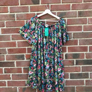  - Helt oanvänd ny blommig klänning! Kan bäras off shoulder, prislappen är kvar 