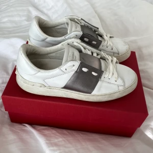 Valentino open sneakers - Vita Valentino skor med silver/metallic band!! Några flaws på tån mm men det syns på bilderna! Inget som är så värst märkbart❤️❤️ storlek 37, passar 38. Box och brevet ingår