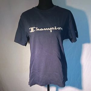 Champion t-shirt  - Mörkblå champion t-shirt, litet minihål nere på ryggen som syns på andra bilden