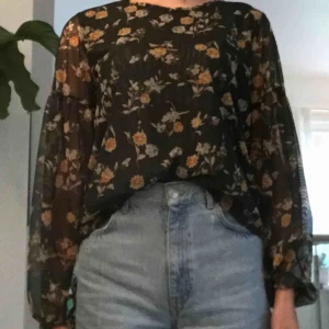  - Grön blommig blus i skirt material med ballongärmar.