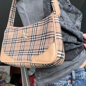 En liten trendig handväska i burberry mönster, med tryck.Inte äkta.Bugvingning , ligger på 200kr