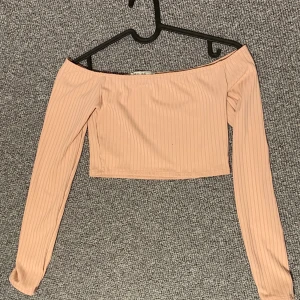 Supersnygg topp - Off shoulder topp i ljusrosa. Jättefin och den sitter väldigt bra på. Den stannar mera på armen och åker inte upp på axlarna så som vissa off shoulder plagg lätt gör. Storlek xs. 