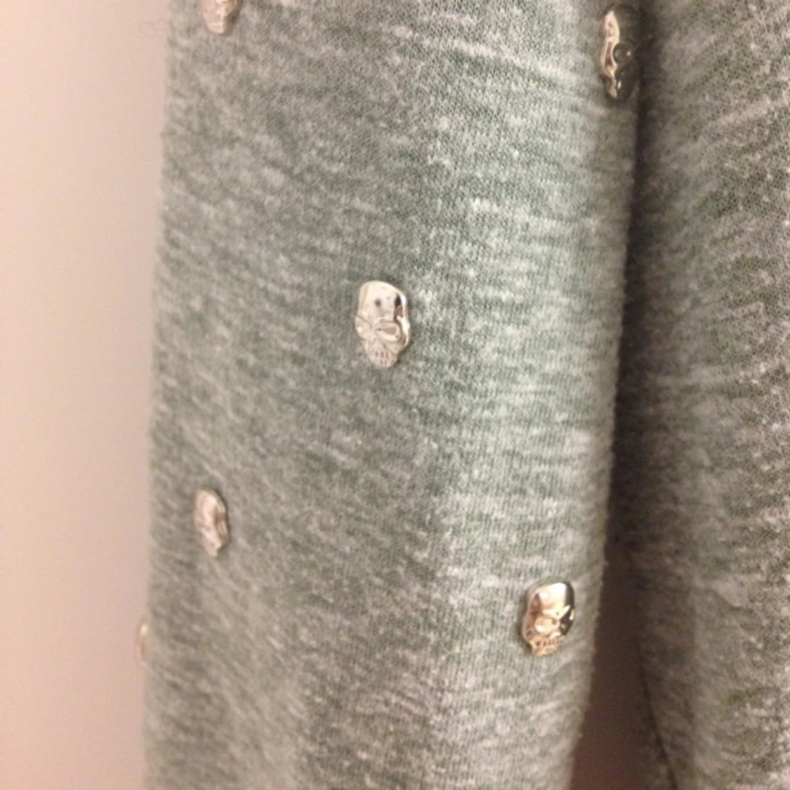 Härlig grön tröja med öppen rygg och dödskallar i silver som smyckar armarna.  - 1425923747