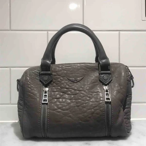  - Säljer denna snygga Zadig Voltaire väska i modellen ”sunny xsmall”. Köptes för 1,5 år sedan för 3500kr. Säljes för 1700kr! Så passa på!☠️ Den är i en mörkgrå färg och är i toppskick. Måtten är 23cm x 14cm. (Pris kan diskuteras!)  