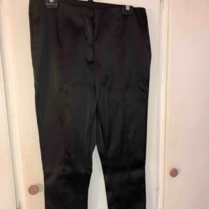  - Svarta blanka kostymbyxor i stl 44, men som även kan passa stl 42. Från hm   100 kr + frakt eller bud 