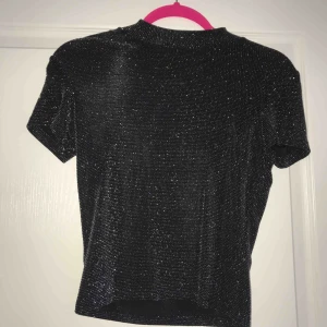  - En svart/silver-glittrig kortare topp ifrån Monki✨ Passar även S!