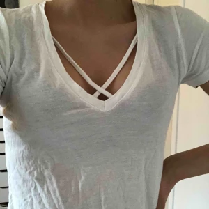  - Jättefin vit t-shit med band över brösten från Gina. Nästan nytt skick förutom ett jättelitet hål vid sidan av midjan, men man ser det knappt 💞