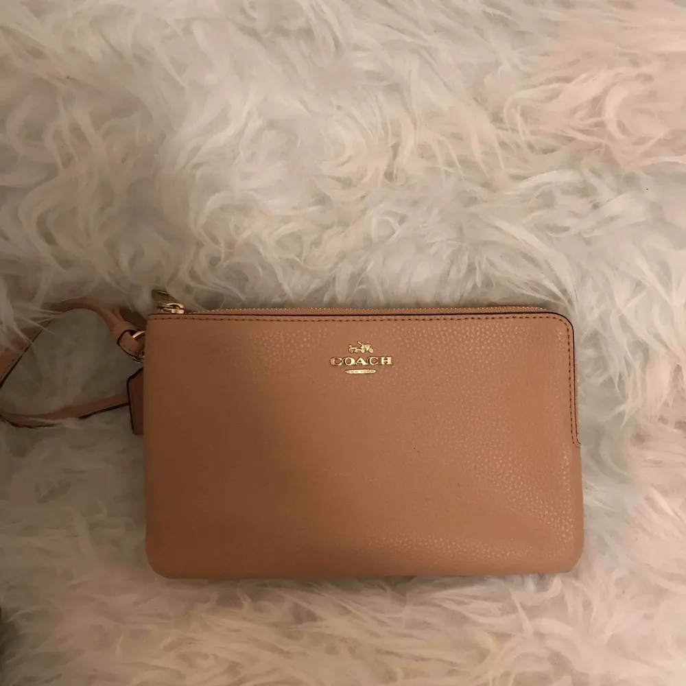 Clutch från Coach (äkta) i en jättefin rosa/beige färg med guld detaljer. Ursprungspris 1100 kr, säljes för 250 kr. Kan fraktas.. Accessoarer.