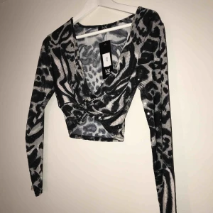  - Festlig shimrande kroppad topp ! Som är i helt nyskick , aldrig använd bara testad( prislapp kvar) en super fin kroppad topp som har lite svart vitt grått mönster !!                  🌸ny pris - 150kr🌸