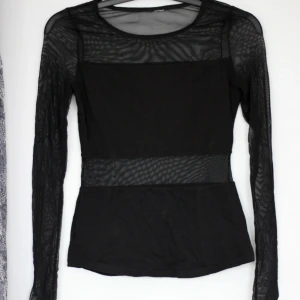  - Genomskinlig topp med partier av tyg. Ryggen har samma partier med tyg. Köpt på H&M Divided, storlek XS. Sparsamt använd.  Möts upp i Göteborg eller fraktar mot betalning.