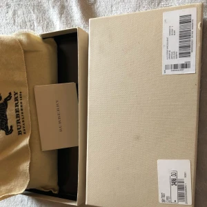  - Äkta Brunt Burberry plånbok läder med boxvårdskort och prislapp med dammpåse, i mycket gott skick, för mer information skickade mig meddelanden kan jag också skicka fler bilder på begäran via e-mail .. 😊 priset är lite förhandlingsbart