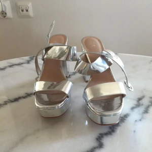  - Ett par silver klackar! Aldrig använda! Köparen står för frakten på 60kr