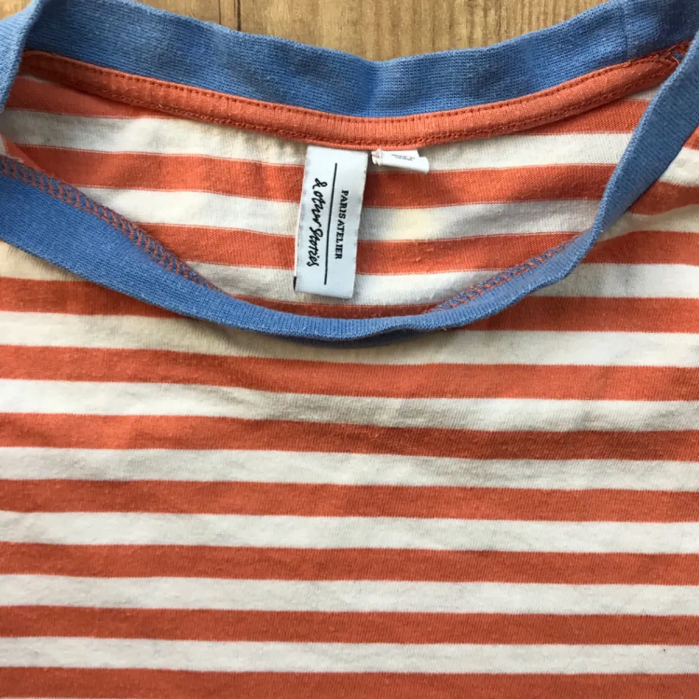 T-shirt from & other stories. Coral striped with sky blue collar line. It’s very lovely especially for the summer days. Sturdy cotton for a shirt, not the thin kinds that breaks after a few wears. . T-shirts.